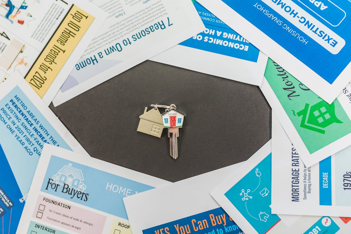 Mortgage closing documents being signed on a desk with house keys representing refinance closing costs