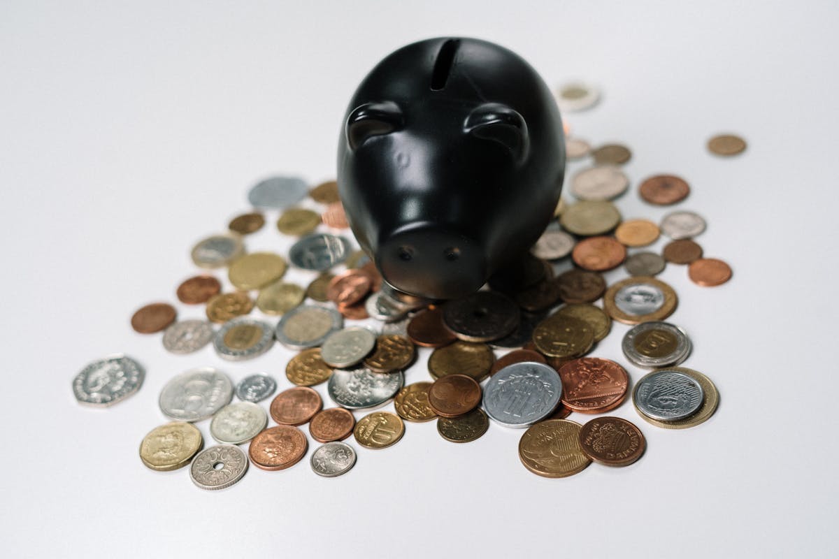 Piggy bank on a desk with coins representing home finance lump sum decisions for recasting or refinancing